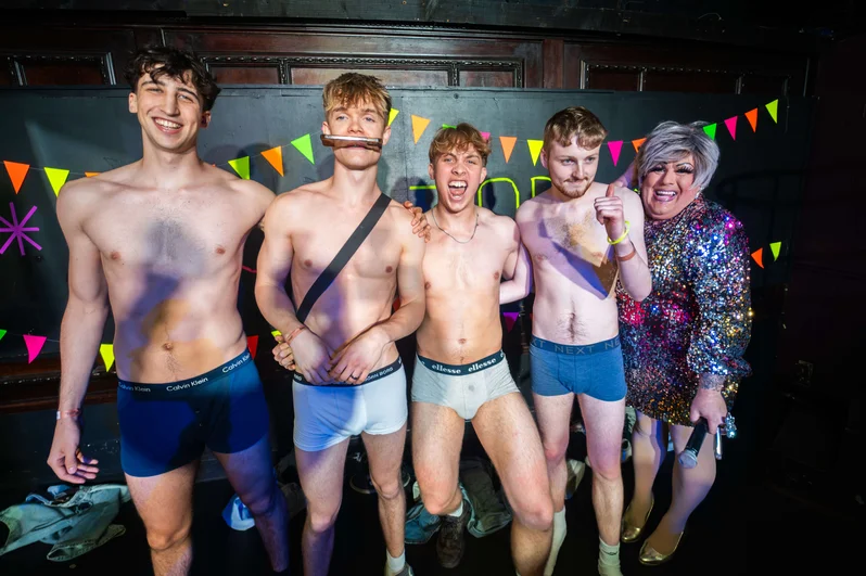 Young men in underwear pose with a drag queen at OMG Bristol Club